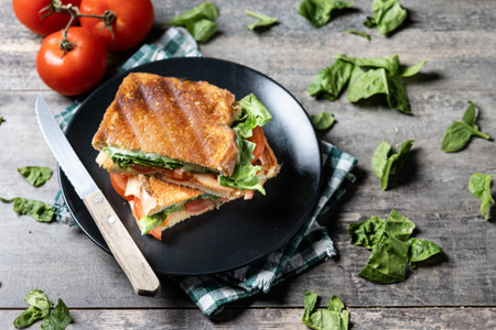 Healthy spinach, tomato and cheese sandwich on wooden tableの写真素材