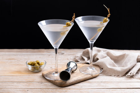 Vodka martini cocktail with vodka and vermouth and green olives on wooden tableの写真素材