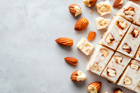 Pieces of delicious almonds nougat with white chocolate on light gray tableの素材