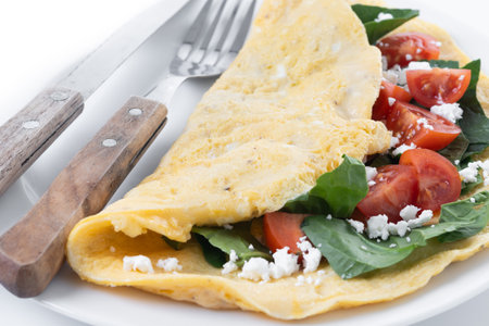 Stuffed omelette with tomatoes and spinach isolated on white backgroundの写真素材