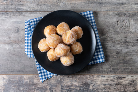 Traditional Carnival fritters or buÃ±uelos de viento on wooden table