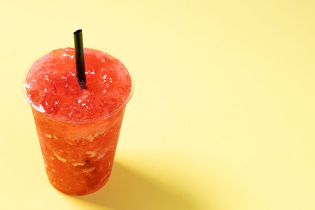 Red strawberry slushie isolated on yellow background.の写真素材