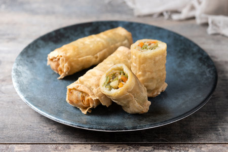 Crispy Spring Rolls on Ceramic Plate on wooden table