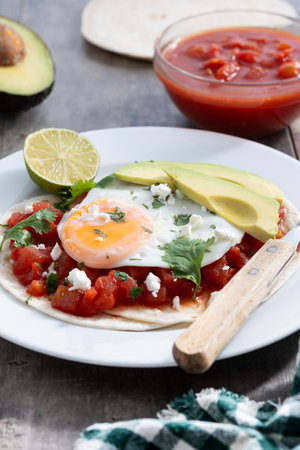 Huevos Rancheros on wooden table. Traditional Mexican breakfastの写真素材