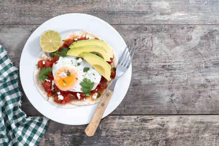 Huevos Rancheros on wooden table. Traditional Mexican breakfast. Top view. Copy spaceの写真素材