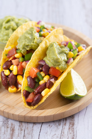 Vegan mexican Taco with beans and guacamole on wooden tableの写真素材