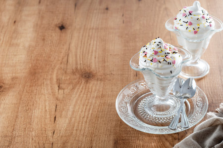 Whipped Cream Delight with Sprinkles on wooden tableの写真素材