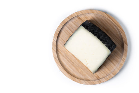 Close-up of a wedge of semi-cured cow's cheese isolated on white backgroundの写真素材