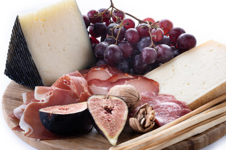 Charcuterie Board with Cheese, Grapes, Figs and wine isolated on white backgroundの写真素材