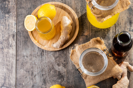 Assorted glass jars and bottles filled with homemade kombucha on wooden table