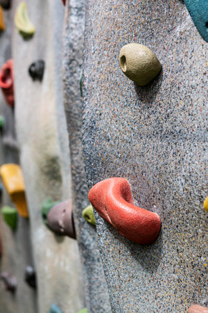 Close-up view of colorful climbing holds on an artificial rock wall.