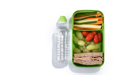 Healthy Lunchbox for school with sandwich,fruit and vegetables isolated on white backgroundの写真素材