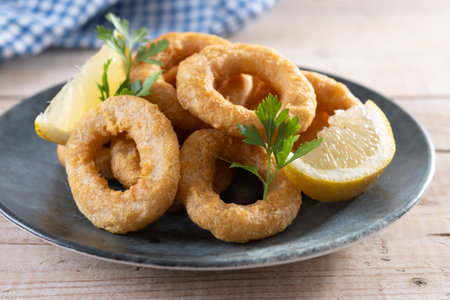 Closeup of crispy calamari rings served on wooden tableの写真素材