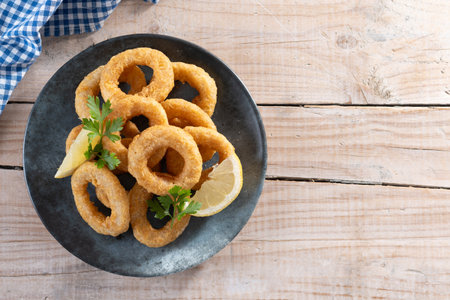 Closeup of crispy calamari rings served on wooden tableの写真素材