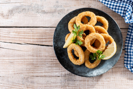 Closeup of crispy calamari rings served on wooden tableの写真素材