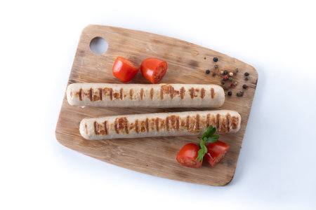 Grilled Bratwurst sausages with cherry tomatoes and parsley isolated on white backgroundの写真素材