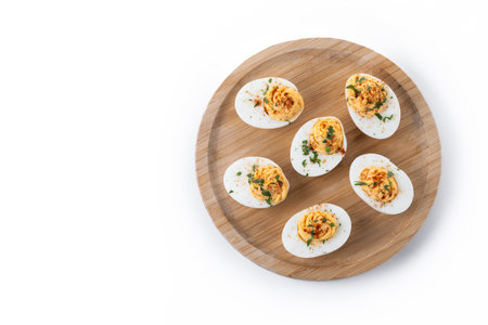 Homemade hard Boiled Deviled Eggs garnished with herbs isolated on white background