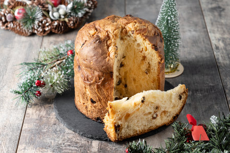 Traditional Italian Panettone on wooden table and christmas tree backgroundの写真素材