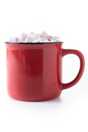 Warm hot chocolate with pink and white marshmallows served in a red mugの写真素材