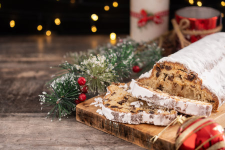 Traditional Christmas Stollen with Raisins and Powdered Sugar on wooden tableの写真素材