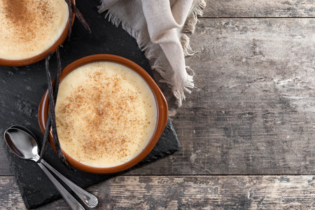 Creamy homemade Spanish custard served in a bowl on wooden tableの写真素材