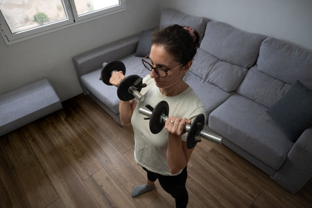 Woman doing triceps exercise with dumbbell at home
