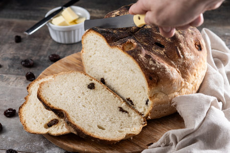 Traditional Irish soda bread with raisins, freshly baked and sliced, served on a rustic wooden board...