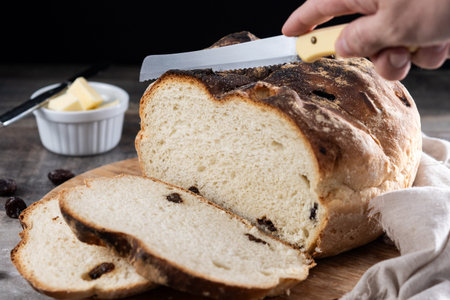 Traditional Irish soda bread with raisins, freshly baked and sliced, served on a rustic wooden board...