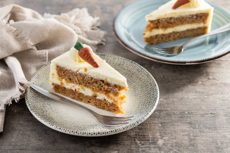 Carrot cake slice with cream cheese frosting on wooden table