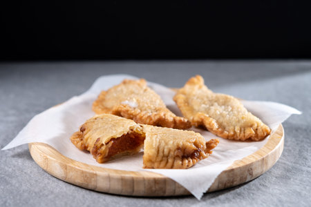 Homemade sweet pumpkin empanadillas on wooden table
