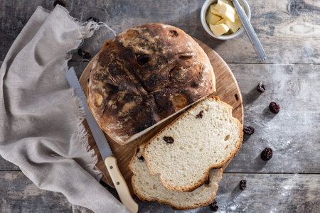 Traditional Irish soda bread with raisins, freshly baked and sliced on wooden tableの写真素材