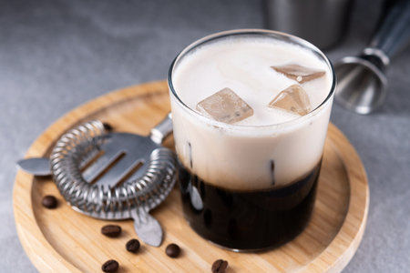 Refreshing Boozy White Russian Cocktail with Vodka and Cream on gray stone background