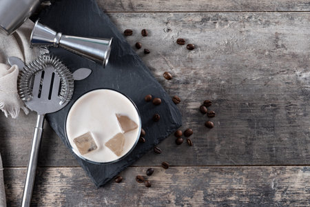 Refreshing Boozy White Russian Cocktail with Vodka and Cream on wooden table