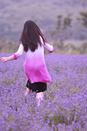 Woman running in the lavender fieldの写真素材
