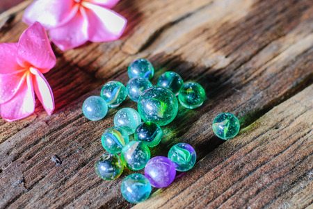 group of mables on wood and red plumeriaの写真素材