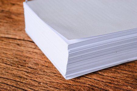 Stack of a4 size white paper sheet on old woodenの写真素材