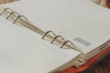 Open Notebook or Journal with blank lined pages for copyspace on a wood backgroundの写真素材