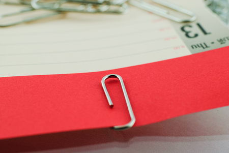 Paper clip and red paper on white backgroundの写真素材