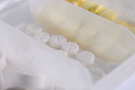 Heap of white and yellow round medicine tablet antibiotic pillsの写真素材