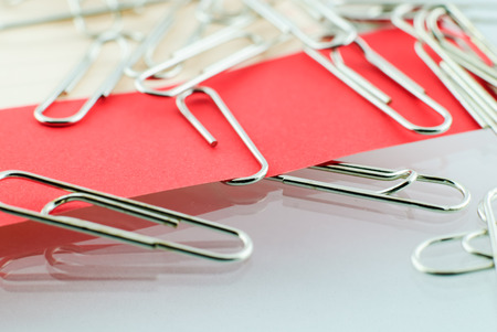Paper clip and red paper on white backgroundの写真素材