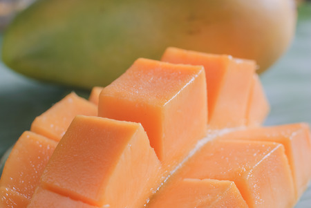 Ripe mango with slices on banana leaves of background