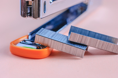 Red office stapler isolated over red background