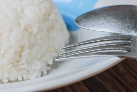 rice in white dish with spoon and forkの写真素材