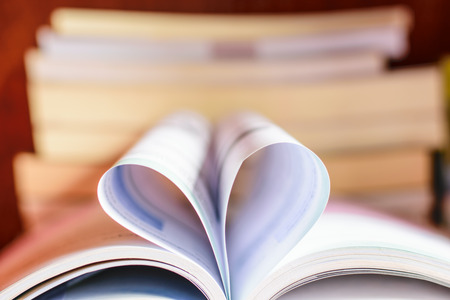 opened book, lying on the bookshelf with a heartの写真素材