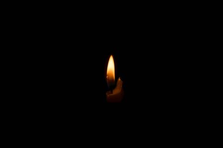 candle burning in the dark, isolated on black backgroundの写真素材