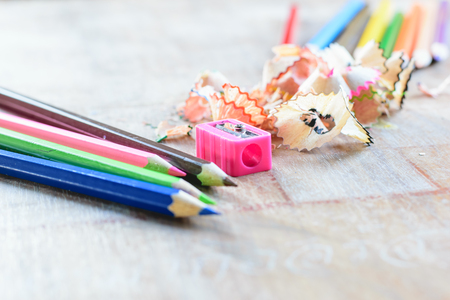 Wooden colorful pencils with sharpening shavings, on wooden tableの写真素材