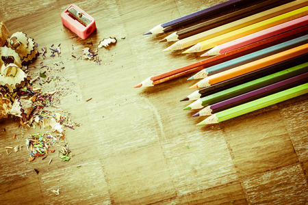 Wooden colorful pencils with sharpening shavings, on wooden tableの写真素材