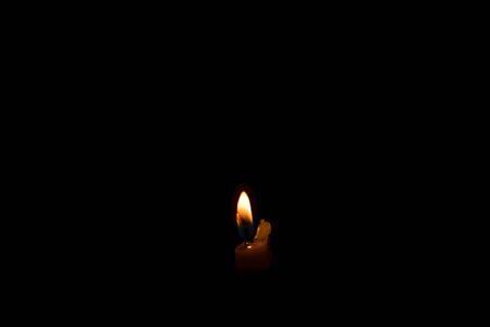 candle burning in the dark, isolated on black backgroundの写真素材