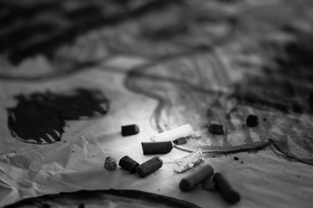 Crayons lying on an abstract hand drawing backgroundの写真素材
