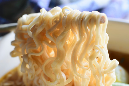Chinese noodles with minced pork and egg in bowl on wooden table